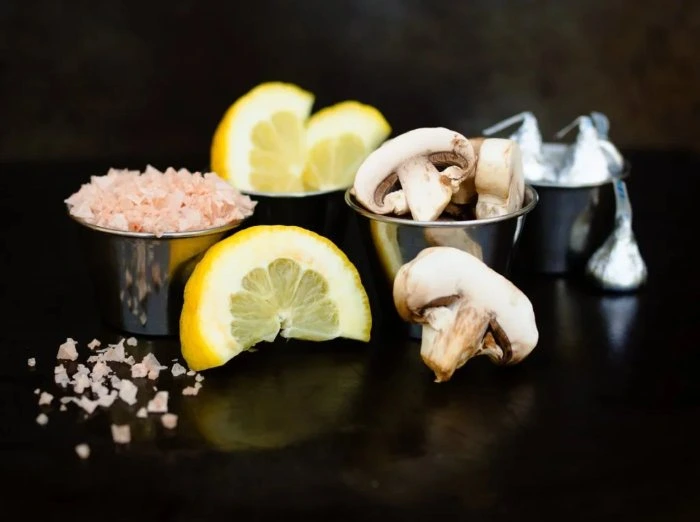 Sale rosa dell'Himalaya, limoni, funghi e baci di cioccolato per simboleggiare i sapori acido, salato, umami e dolce