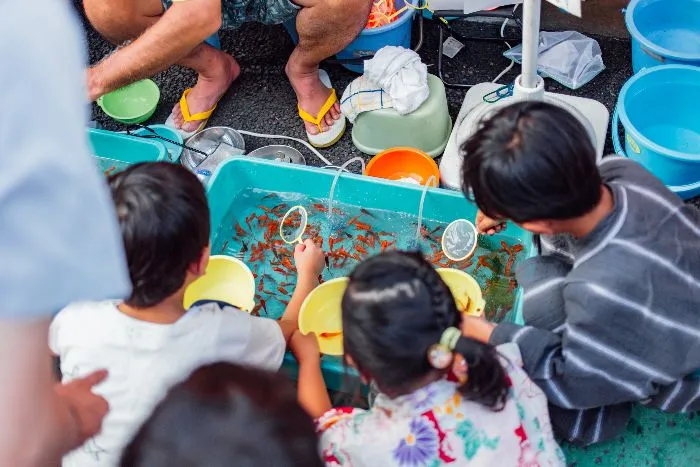 Bambini che giocano alla pesca tipica nei festival giapponesi