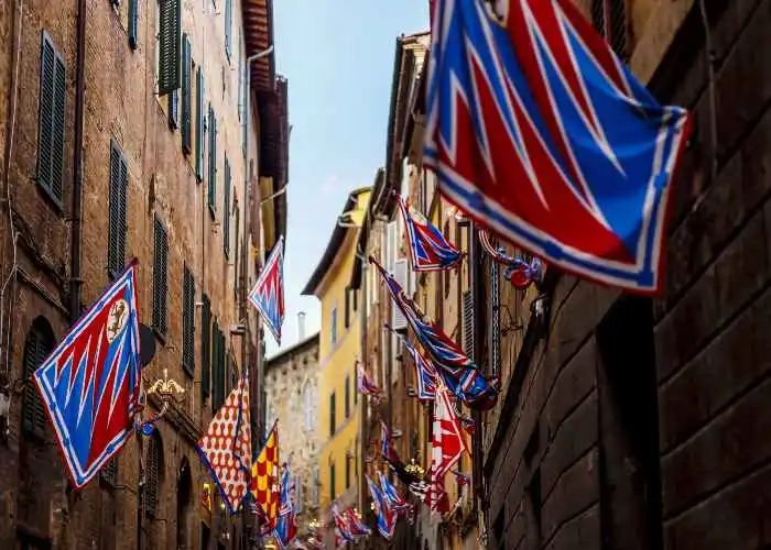 Bandiere del Palio lungo una via di Siena