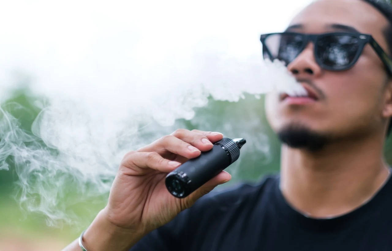 Un ragazzo fuma una sigaretta elettronica