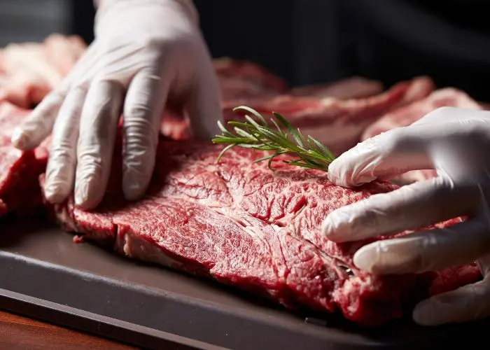 Uno chef prepara della carne rossa