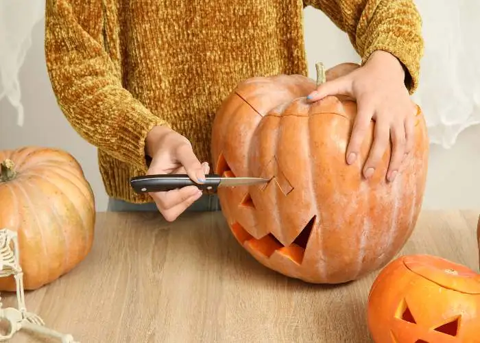 Una ragazza intaglia una zucca di Halloween