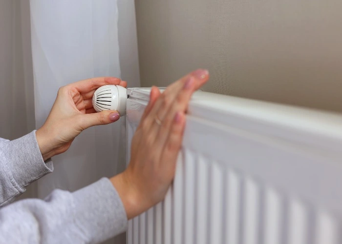 Una donna accende il termosifone