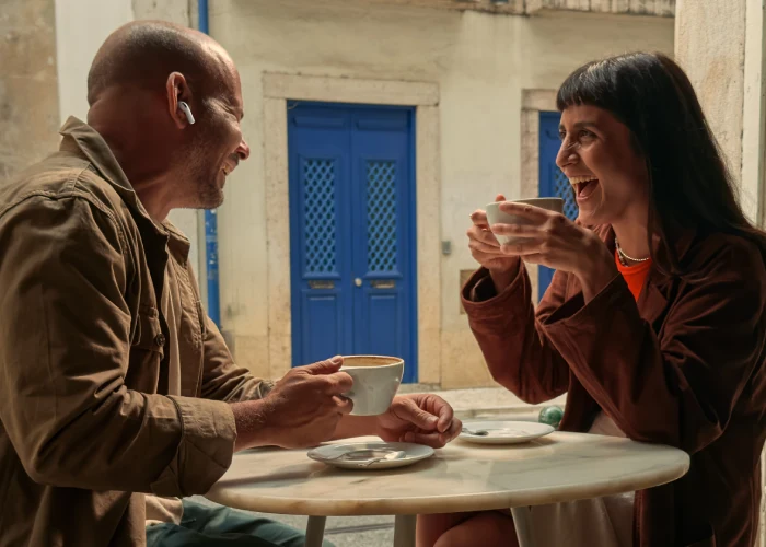 Due persone parlano con Apple AirPods Pro 3