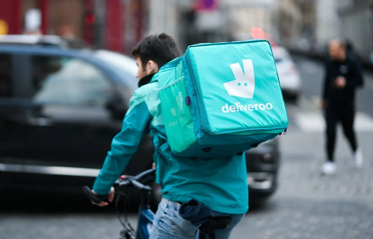 Un rider di Deliveroo mentre consegna cibo