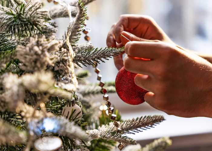 Una persona addobba l'Albero di Natale