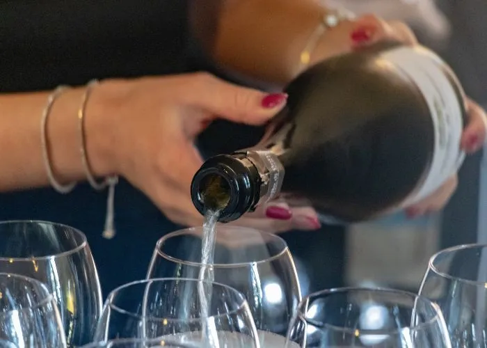 Un sommelier versa lo spumante Franciacorta in bicchieri per degustazione