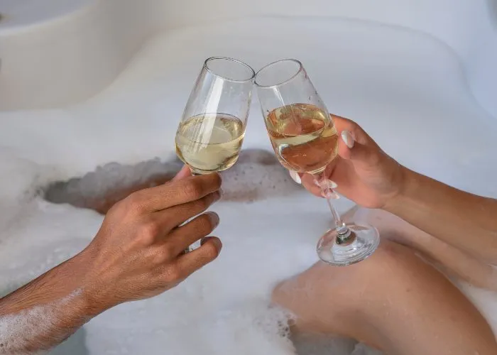 Una coppia beve champagne in una vasca idromassaggio