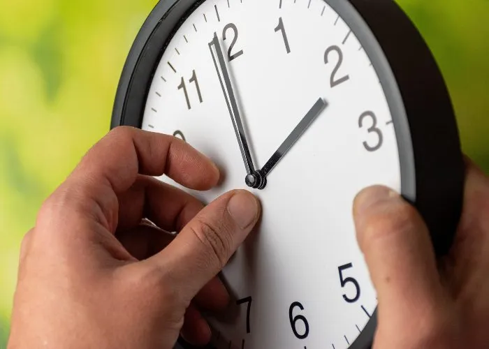 Un uomo mentre cambia l'ora al suo orologio