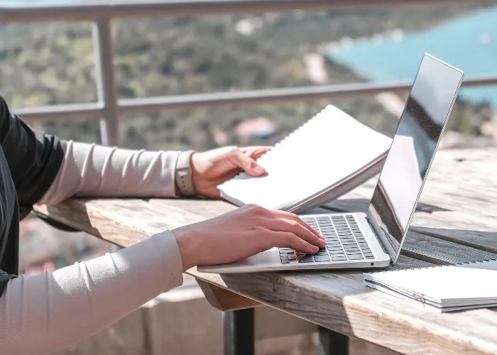 Una ragazza mentre lavora all'aperto con il suo pc portatile