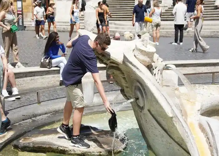 effetti di El Niño in Italia - Per il gran caldo a Roma un turista si rinfresca alla fontana della Barcaccia a Piazza di Spagna