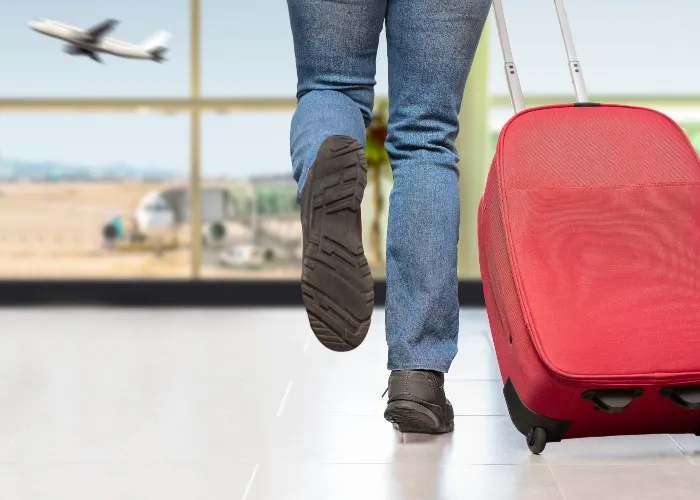 Come organizzare una vacanza last minute - Ragazzo con valigia in aeroporto