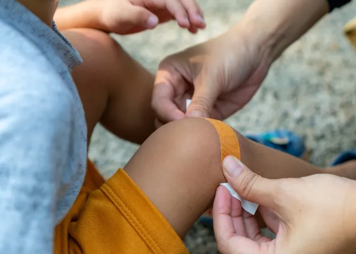 Madre mette un cerotto al figlio