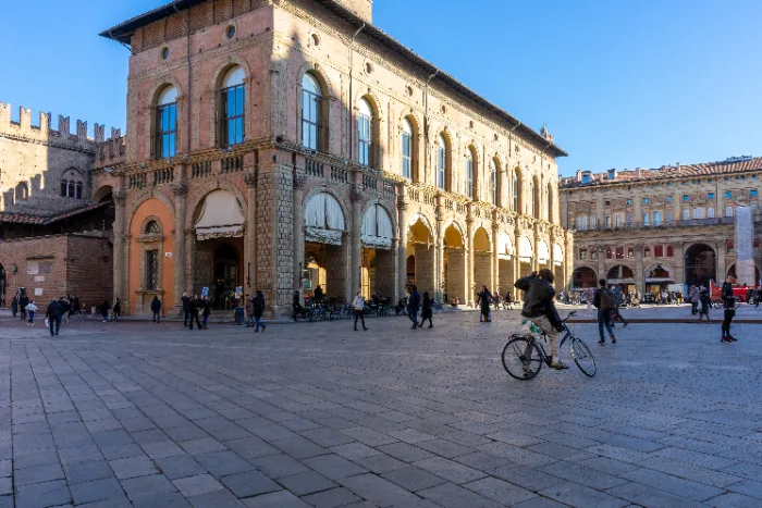 Ciclista in piazza Maggiore a Bologna, accanto a Palazzo Re Enzo