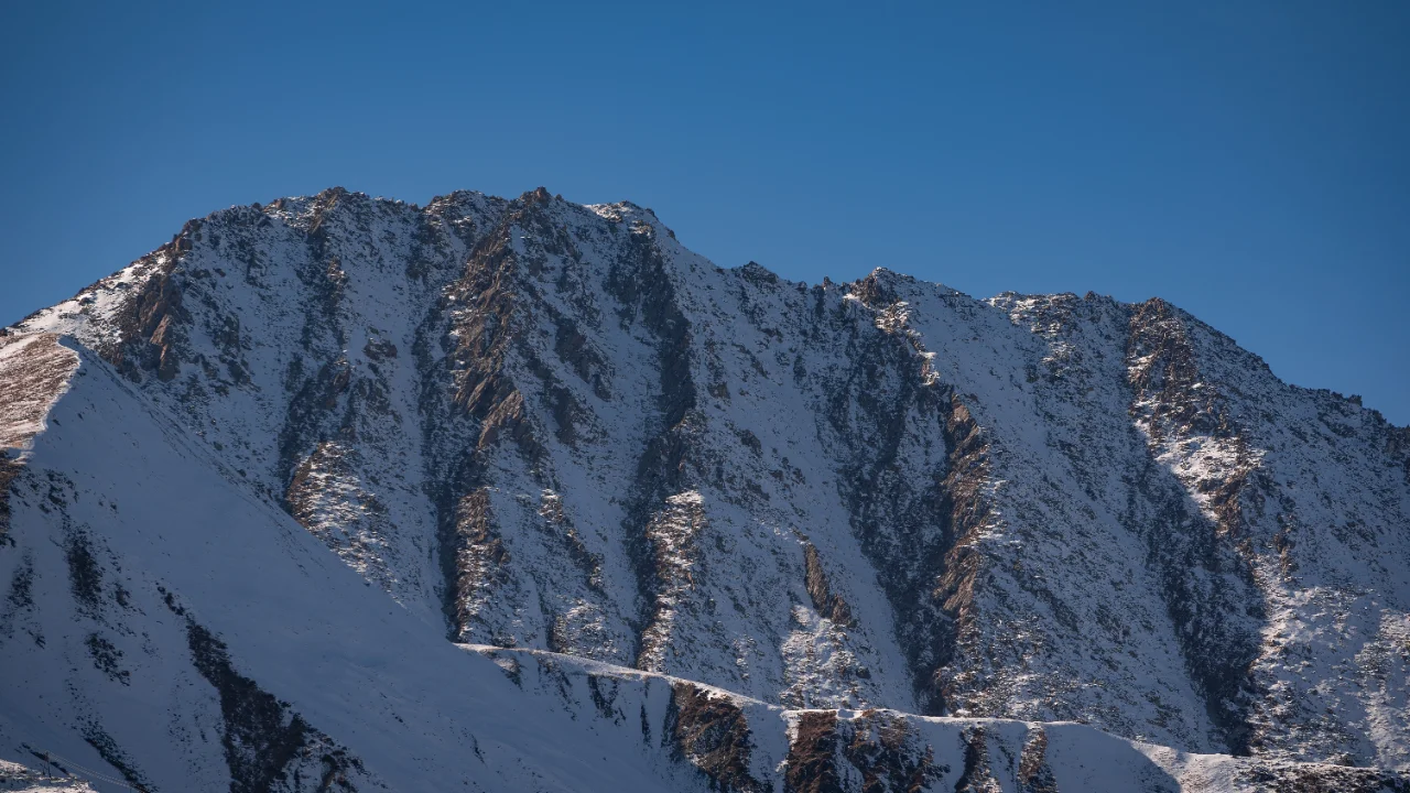 Chiusura invernale dei passi alpini: tornanti di un valico di alta quota con la prima neve