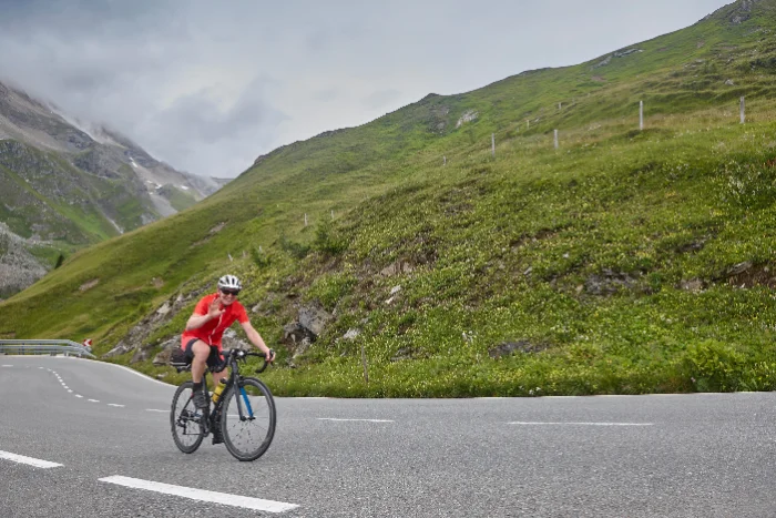 Ciclista su una strada di passo alpino