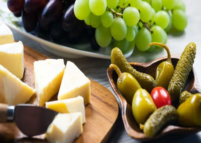 Formaggio, uva, olive e cetriolini.