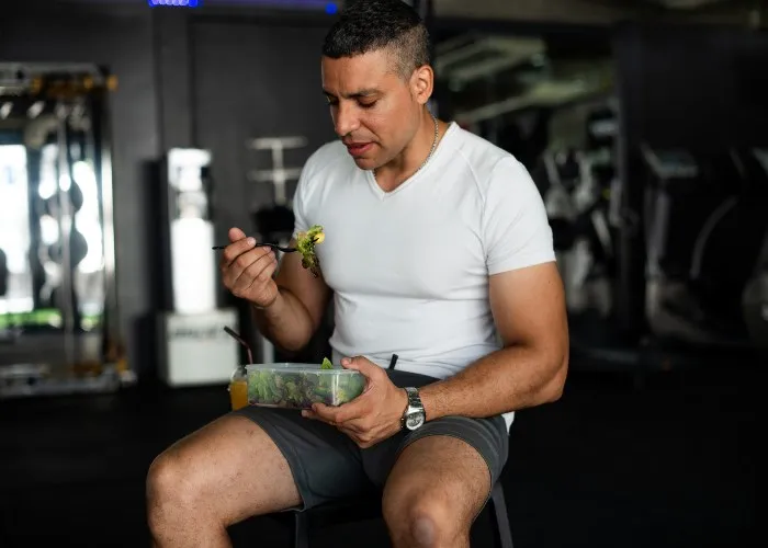 Un ragazzo mangia dopo un allenamento in palestra