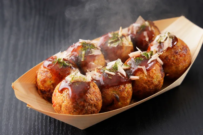 Takoyaki, le polpette di polpo, servite in una vaschetta di legno