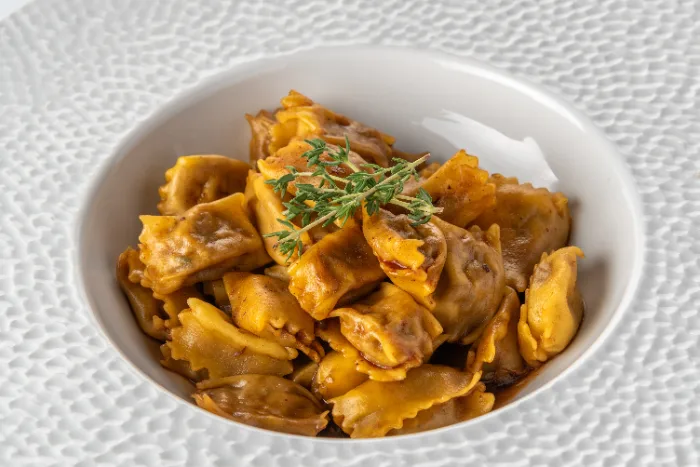 Piatto di agnolotti del plin conditi con sugo d'arrosto, specialità piemontese
