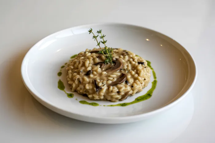Porzione di risotto cremoso ai funghi servita in un piatto fondo