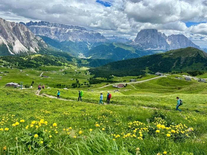 Escursionisti lungo un sentiero di montagna in Val di Fassa, che ora combatte contro l'overtourism.