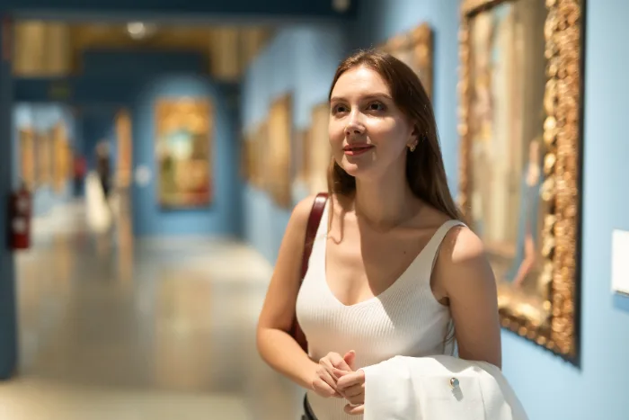 Visitatrice in un museo davanti ai dipinti